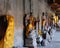 Buddha statues in golden robes stand along the walls of an ancient temple. A place of religious worship. An example of religious