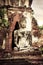 Buddha at Wat Mahathat ruins under sunset sky. Thailand