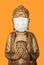 Buddha wooden statue wearing face mask