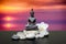 Buddha,zen stone,white orchid flowers.In the background sunrise over the sea