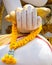 Buddhas hand with flower garland. Thailand