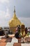 Buddhist devotees praying in front of the Golden Rock at Kyaiktiyo Pagoda