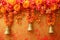 Buddhist golden bell hanging on festival background with orange marigold flowers. Ritual hand bell in Buddhist temple