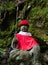 Buddhist Jizo statue in red garments on a mountain path leading to Iwayaji, temple number 45 of Shikoku pilgrimage