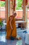 Buddhist monk doing some cleaning at buddhist temple from Damnoen Saduak Floating Market