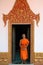 Buddhist monk in door with carved golden ornaments of monastery in Cambodia