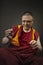 Buddhist monk holds a candle and lights an incense stick