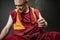 Buddhist monk holds a candle and lights an incense stick