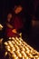 A buddhist monk lights butter lamps