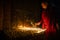 Buddhist monk lights a  candle