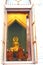 Buddhist monk performing religious ceremony infront of main holy Golden Buddha statue in temple pavillion