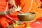 Buddhist monk\'s hand pouring melt candle tears to the water for making blessing water