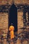 Buddhist monk standing in front of ruin old front Wat Ratburana