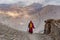 Buddhist monk walking road mountain village India clouds