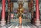 A buddhist Monk is worshiping and praying pay respect in front of the Golden buddha statue