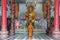 A buddhist Monk is worshiping and praying pay respect in front of the Golden buddha statue