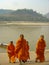 Buddhist monks climb up stairs by Mekong River