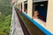 Buddhist novice monk looking out of train that passing the famous viaduct Goteik between Pyin Oo Lwin and Hsipaw in Myanmar