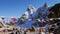 Buddhist prayer flags waving in the cold wind on the summit of Renjo La pass, Himalayas, Nepal with ice-capped mountains.