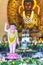 Buddhist statue in temple decorated lights, colorful flowers on Buddha`s birthday.