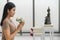 Buddhist woman holding lotus flowers worship to buddha statue at home