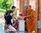 Buddist monk blesses religious people at Damnoen Saduak temple, Thailand