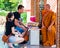 Buddist monk blesses religious people at Damnoen Saduak temple, Thailand