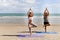 Buddy athlete woman, man doing yoga and stretching body on summer island beach, couple practicing yoga at seashore of tropical