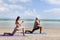 Buddy athlete woman, man doing yoga and stretching body on summer island beach, couple practicing yoga at seashore of tropical