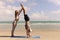 Buddy athlete woman, man doing yoga and stretching body on summer island beach, couple practicing yoga at seashore of tropical