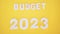 Budget for 2023 wooden figures on a yellow background