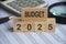 Budget 2025 text on wooden blocks with data analysis and office concept background. Budgeting concept