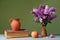 Budleja in a ceramic vase, apple and books