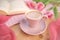 Buds of spring flowers, pink tulips, a cup of cappuccino, book on a wooden table, concept of spring, women`s lifestyle, morning