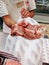 Budva, Montenegro - 01 august 2020: The butcher in the store shows meat.