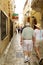 Budva / Montenegro - July 21, 2014: Married couple of elderly tourists in shorts on narrow cobbled street of old town in the