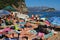 Budva, Montenegro, Mogren beach. August 15 2022 Sand and pebble beach near high cliffs. Beach umbrellas, cafes, deck