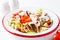 Buffalo chicken salad with blue cheese, tomato, cucumber and ranch dressing, white tile background