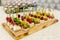 The buffet at the reception. Assortment of canapes on wooden board. Banquet service. catering food, snacks with cheese, jamon and