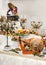 Buffet table with meat snacks, dried pork leg, baked pigs in dough with fruit, decorated with candelabra and gramophone