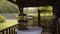 Buffet table in wooden rural gazebo in yard. Snacks and fruit stand on board.