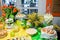 Buffet with a yellow-green tablecloth with snacks, desserts and a bouquet of tulips