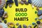 Build good habits symbol. Words `Build good habits` on a beautiful yellow background. Sea stones and seashells. Business,