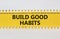 Build good habits symbol. Words `Build good habits` on white and yellow paper. Beautiful yellow background. Business, psychology