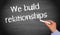 We build relationships - female hand with chalk writing text