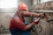 Builder on a construction site working on a brick wall with a hammer