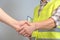 The builder and the customer shake hands on a gray background. Teamwork, cooperation, the concept of successful cooperation