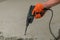 A builder dismantles a perforator drill breaks the concrete floor at a construction site