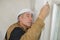 Builder drives screws into ceiling fiberboard with screwdriver