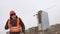 Builder evil architect man worker shakes hands in helmet and orange vest against the background of a multi-storey winter